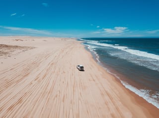 Een 4x4 op een strand met golven