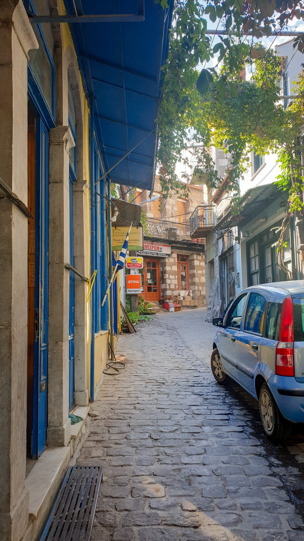Een geparkeerde auto in een smalle dorpsstraat op Les Bos