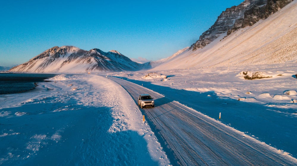 Sneeuwlandschap met 4x4 op de weg in IJsland