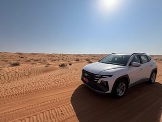 Witte auto in woestijn Oman