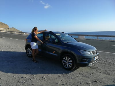 Vrouw naast een SUV op een Spaanse weg